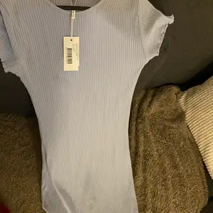 En baby blå klänning från nelly som är oanvänd i storlek M