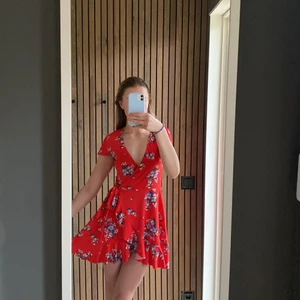 RÖD KLÄNNING MED BLOMMOR PÅ - En jättegullig röd klänning med blommor på! Vill få sålt snabbt så tar nästan vilket bud som helst! 