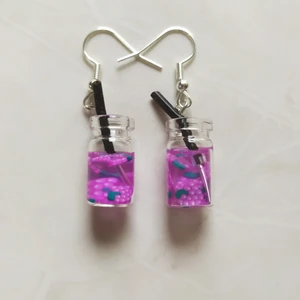 Örhängen - Fruktdrink - Nya oanvända nickelsäkra örhängen. Berlock med behållare av glas. Handgjorda i Sverige. Höjd ca 20mm. Levereras i förseglad förpackning.