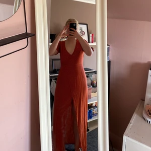 Röd sommarklänning  - Jättefin röd långklänning med orangea prickar från NA-KD. Max använd 3gånger, i ett skönt och luftigt material med en slits framtid och små knytningar vid armarna. Nypris på 500kr. Säljer pågrund av att jag inte använder den🌼 frakten står köparen för om möte inte funkar! 