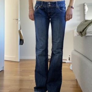Lågmidjade jeans - Ett par super snygga utsvängda lågmidjade jeans med döskallar på fickorna. Har fyra små hål på insidan då de var lite stora i midjan men det är inget som syns då de sitter på insidan, syns på sista bilden💕💙midjemåttet: 80cm innerbenslängden: 85cm