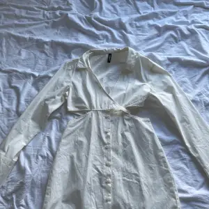Säljer nu min vita skjortklänning då den blivit för liten. Väldigt charmig modell på den. Knappar fram och sen knyter man den i bysten för att få fram en form. Den har även vita på sidan för att framhäva lite. Passar till både fest och vardag!