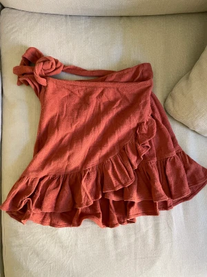Volangkjol från Zara strl 34 - Kommer i bra använt skick. Trådningar finns men inget som störs. Brun/röd färg? 