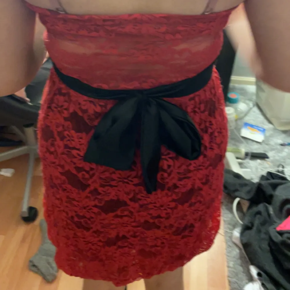 En fin röd klänning med mönster med rosett där bak. Klänningar.