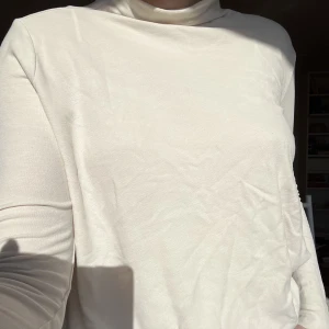 beige polo - superlyxig beige/krämvit polotröja i ett tunt flowigt material från kos. har en ”scrunch” i sidan vilket får den att sitta jättesmickrande. sparsamt använd och funkar året om!
