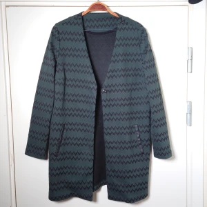 Kofta - Turkos och svart-mönstrad kofta/öppen tröja som kan knäppas med en knapp. Ingen storleksmärkning men passar M