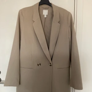 Kavaj/ Blazer  - Oversized kavaj/blazer i beige, med knappar. Har använts 1 gång. 