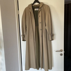 Trenchcoat - Trenchcoat i jättefint skick!! Fodrad enligt sista bilden. Den saknar band att knyta runt midjan, hölsor finns. Och hänget är trasigt enligt sista bilden. Annars är den hel och ren. Ej storleksmärkt men jag har vanligtvis 36/38🌷🌷