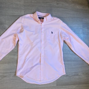 Ljusrosa polo skjorta  - Skön polo skjorta med fin ljusrosa färg, skjortan är knappt använd så är bra skick på den. Hör av er för fler bilder eller förslag på pris.