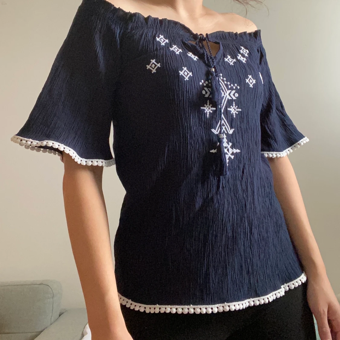 Mörkblå blus med vita broderier 