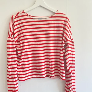 Rödrandig tröja  - Superpopulär rödrandig tröja från GinaTricot. Tröjan är i ett tunnt, skönt material som passar perfekt på lite kallare sommardagar. Den är använd ett fåtal gånger men har inga tydliga tecken på slitage. Extra detalj på ärmarna. Skriv för fler bilder!