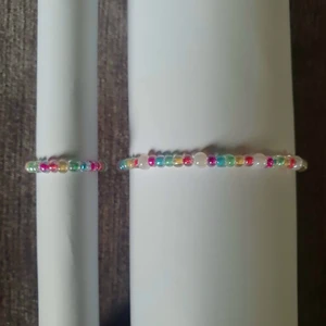 Armband och ring set! - Ett set med ett armband och en ring i regnbågsfärger! Båda är gjorda i elastisk tråd som går att stretcha lite, men storlek är ändå valfri! 10% av kostnaden går till organisationen Mind! 💓