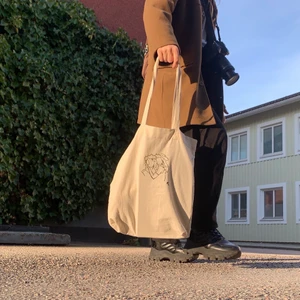 Tygväska med eget tryck  - En vit tygväska med ett eget tryck jag gjort av linoleumplast. Går att få i olika färger. Rymmer 10l. Handtagen är 67cm långa. Gör dessa efter efterfrågan! Tvättbar 40°