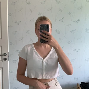 Vit croppad topp - Vit söt croppad topp med volanger. Tshirt ärmar och knappar