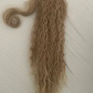 en curly blonde ponytail som man sätter över en liten boll sen vrider man runt en slinga och fäster den. nästan oanvänd satt på och tagit av bara, och orginalpris var 250kr