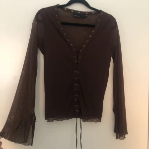 Brun mesh lace-up top  - Storlek 38/40 men tyget är stretchigt så passar även större storlekar. I gott skick utan hål i meshet. Från Kappahl för ungefär 15 år sedan. Bell sleeve med eget snöre. Köpare står för frakt. Bara att dm:a vid frågor❤️