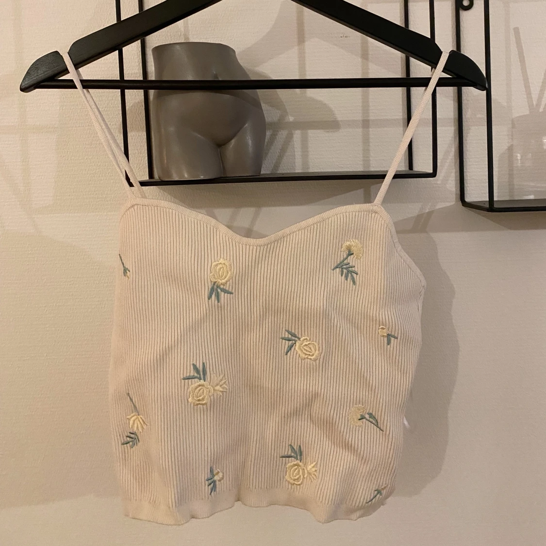 Vit topp med blommor på