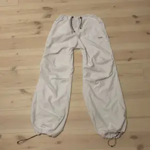 As coola och trendiga vita trackpants från Urban outfitters egna märke. De är i jätte bra skick och har en väldigt fin pass form! Luftiga och smidiga och har justerbar midja och ben slut!  Originalpris: 700kr