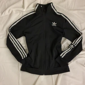 Adidas kofta - Nu säljer jag denna jättesnygga Adidas koftan som är i nytt skick då jag inte använt den så mycket, då jag har andra koftor. Säljer ändast vid högt bud då det är ett märkesplagg. Endast seriösa budare!
