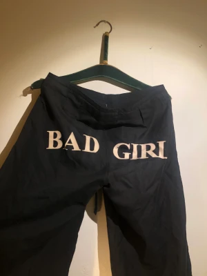 ”Bad girl” svarta jumperbyxor - Svarta, stora, lösa jumperbyxor med tajt midja ”Bad girl” skrivit på rumpan