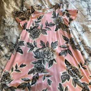 Klänning  - Super fin rosa klänning med svarta blommor på. Köpt på Lindex för några år sedan och endast använd ett fåtal gånger. Älskar den men den är tyvärr för liten därför säljs den. Offshoulder men samtidigt inte.  Frågor?  Skriv i DM  Köparen står för frakten.