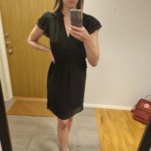 HM Klänning  - Svart klänning från Hm, använd endast en gång och säljer nu då den inte är min stil längre. I nyskick. Super fin urringning och snören i midjan som gör det möjligt att dra åt klänningen.