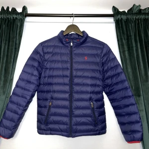 Polo Ralph Lauren Jacka - Säljer min urvuxna Polo Ralph Lauren dunjacka. Jackan är i mycket gott skick och det finns inga tecken på användning. Jackan passar dig mellan 160-169 cm skulle jag säga. Skick:9/10 Färg:Blå/Röd Vid frågor hör av er!😊