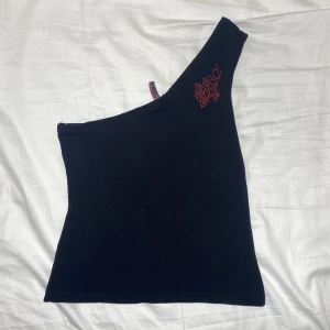 One shoulder tröja y2k - Snygg one shoulder tröja med rhinestones. Felfritt skick, som ny. Strl M men passar flera. DM för bild på!!!Köps genom Swish (frakt 54 kr) eller köp nu 💋