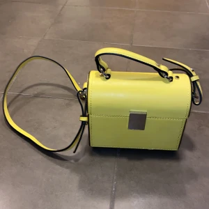 Gul väska  - En fin helt oanvänd väska från Zara.  Färgen är en fin klargul. Litet litet slitage förmodligen från produktion! 