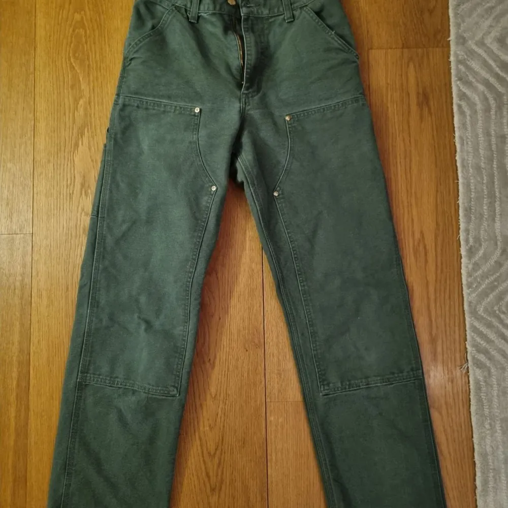 Ett par Carhartt Double Knee byxor i ”box wood green”. Byxorna är i storlek 27x32 och i jätte bra skick!. Jeans & Byxor.