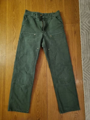 Carhartt Double Knee - Ett par Carhartt Double Knee byxor i ”box wood green”. Byxorna är i storlek 27x32 och i jätte bra skick!