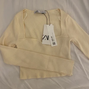 ZARA LÅNGÄRMAD TRÖJA - Långärmad ribbad zara topp/tröja. Liten slits vid armarna. Aldrig använda då den tyvärr är för liten. Färgen är benvit ungefär.