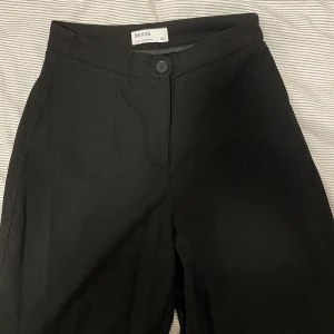 Kostymbyxor - Svarta snygga kostymbyxor från Berska, storlek 36 och knappt använda. Pyttelita korta på mig med proportionerligt långa ben och 168 cm men sitter så snyggt i midjan. Lite mer high waist och lösa i benen.  Köparen står för frakt!