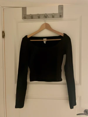 Svart långärmad croptop-H&M Stl S - Svart långärmad tröja i stl S men funkar som M också. Säljer då den inte passar längre. Använd men i fint skick. Endast Swish. 90kr inkl frakt.