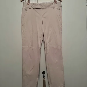 Calvin Klein kostymbyxor - Beiga/Rosa kostymbyxor från Calvin Klein. Använda ett fåtal gånger, superfint skick! Storlek 8 vilket motsvarar storlek M cirka. Skulle säga att de sitter mid/low beroende på hur tight de sitter.  Kan fraktas eller mötas upp i Stockholm. 200kr + frakt 🌸