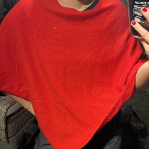 Davida poncho - Superfin röd triangel poncho från Davida. Matrialet är kashmir vilket gör den väldigt mjuk. Använd 2-3 gånger så i princip i nyskick. Färgen är slutsåld online/svårt att få tag på. Perfekt till julen! Nypris: 2300kr