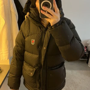 Fjällräven jacka  - Säljer min fjällräven då den inte kommer till användning längre. Köpt förra vintern, och är i bra/nyskick förutom två små vita märken på insidan av luvan (bild 3). Tryck inte på köp direkt tack ❤️‍🔥