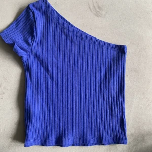One shoulder topp - Jag säljer denna blåa one shoulder toppen som är jätte fin men tyvär blivit för liten för mig💓💓den är i nyskick använt ca 2 gånger🥰