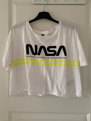 T-shirt  - Vit croppad T-shirt med tryck på framsidan! Storlek L och köpt på hm. Frakt tillkommer