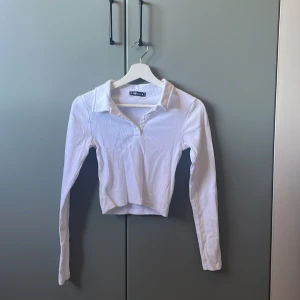 Vit långärmad tröja - Vit långärmad, kroppad med krage och knappar. Väldigt fin. Använd Max 2 gånger. Stl M men passar s