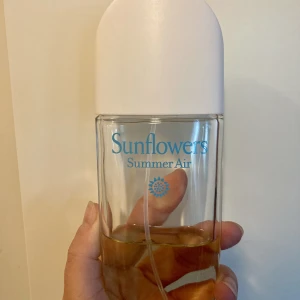 Parfym Elizabeth Arden Sunflower/Summerair Edt - Elizabeth Ardens Sunflower/Summerair Edt, 100 ml, ca hälften kvar (50 ml)  En blommig doft för kvinnor. Den innehåller noter av ozoniska toner, osmanthus, cyklamen, citron, äpple, grön mandarin, mysk, jasmin, ros, bärnsten och cederträ. (Nypris 229 kr)