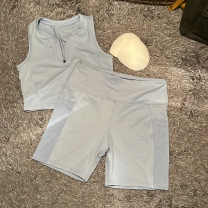 Träningsset - Storlek 40/42 eller M på både byxorna och toppen. Bara testad, säljer för att byxorna var för stora och toppen för liten för mig. Finns kupor som går att ta ut till toppen. Ljusblå, syns inte så bra på första bilden. Bekvämt material. Fickor i shortsen