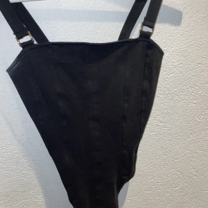 Svart bodysuit  - En skit fin bodysuit från hm, fina guld detaljer på axlarna, sitter väldigt fint den formar kroppen så fint❤️ köparen står för frakten