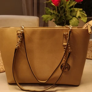Michael Kors väska  - Beige Michael Kors väska inköpt i USA för ca 7 år sedan. Använd men väldigt fint skick, någon enstaka prick/fläck.   Köpare står för frakten.