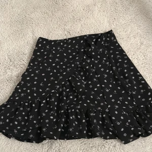 Kjol - Säljer denna svarta kjolen med vita blommor på som är köpt på Newyorker🖤 då jag den är lite kort på mig.