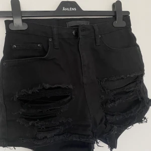 Jeansshorts - Svarta jeansshorts med hål storlek 34