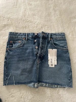Jeanskjol zara - Helt oanvänd jeanskjol från zara med lapp kvar. Storlek M men skulle säga att den är liten i storleken! 