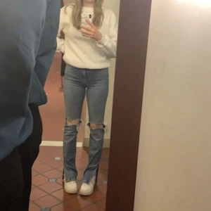 Jeans med slits - Blåa jeans från Zara med slits. Lite slitna längs ner på båda innerbenen, se bild 2! Tvättas såklart innan de skickas!