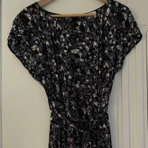 Klänning NoaNoa stl 42 - Klänning i fint skick stl 42 säljes, NoaNoa med kort ärm och knyte fram- eller baktill i midjan.