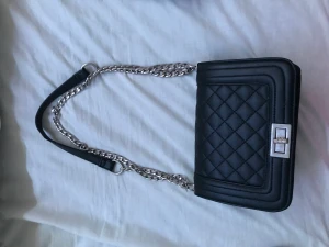 Axelremsväska  - En svart axelremsväska. Använd 1-2 gånger.